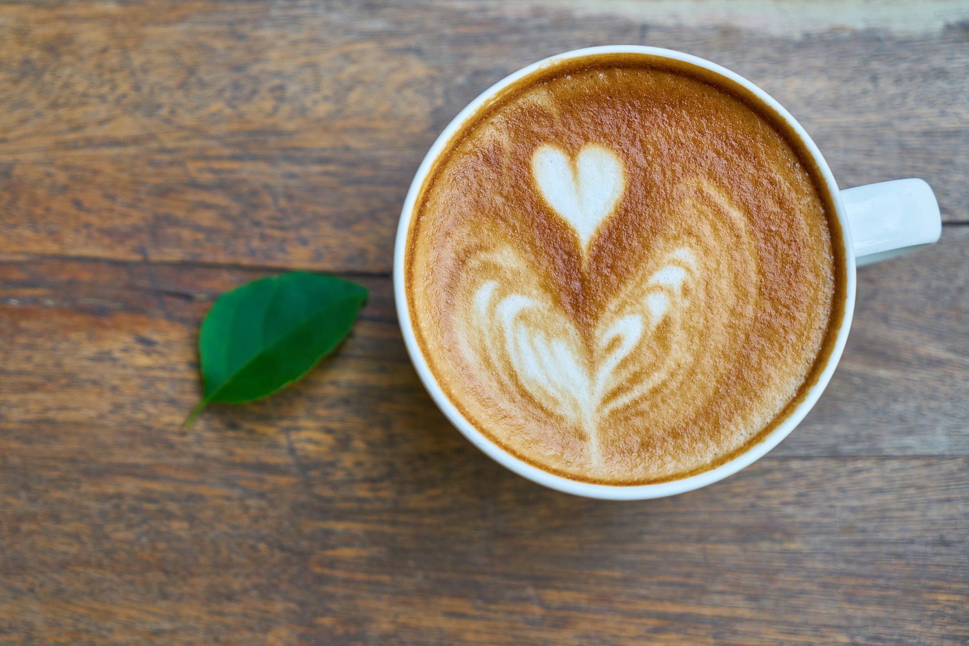Kaffekopp uppifrån med bild av ett hjärta i mjölkskummet.