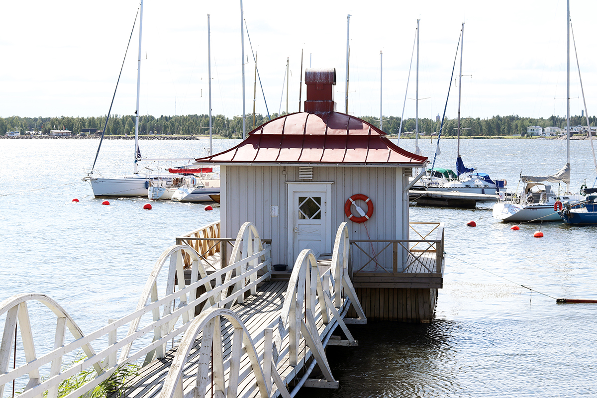 En brygga och badhus samt segelbåtar.