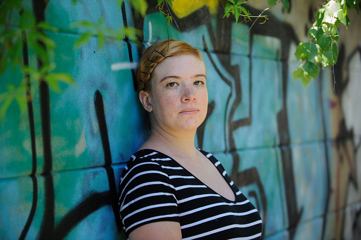 Andrea Westerlund i t-shirt mot en graffitivägg - horisontellt foto.