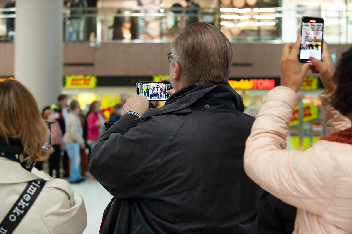 Publik som filmar flashmoben med sina telefoner.