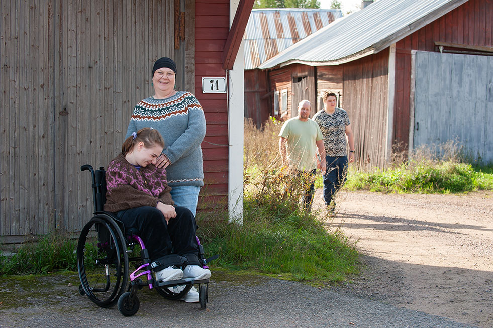 Elin och Ellen Lindroos vid en lada och i bakgruden Joakim och Valdemar Lindroos.