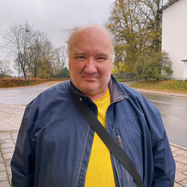 Man med blå rock och gul t-shirt.