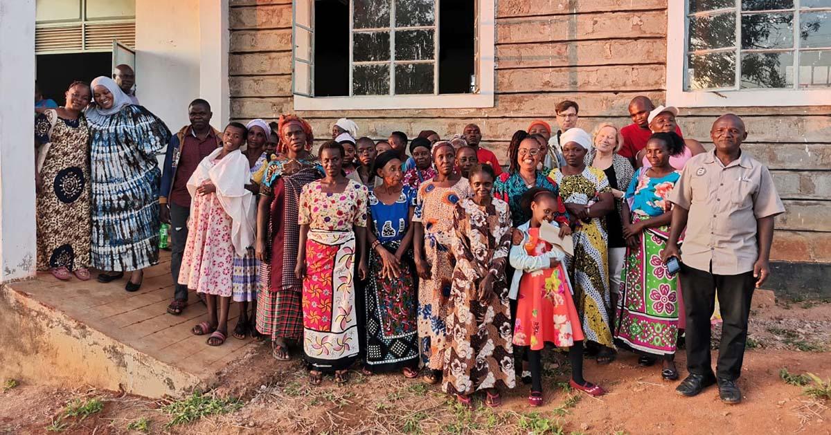 En grupp afrikanska människor utanför ett hus.
