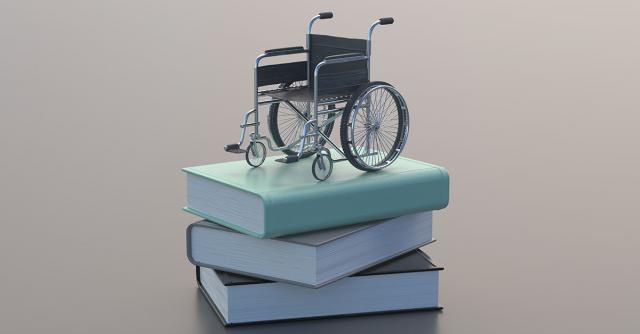 En miniatyrrullstol på en hög med böcker för att illustrerar funktionshinderlagen.