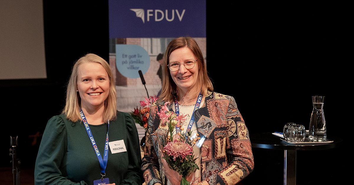Annette Tallberg-Haahtela och Mikaela Björklund framför en FDUV-rollup.