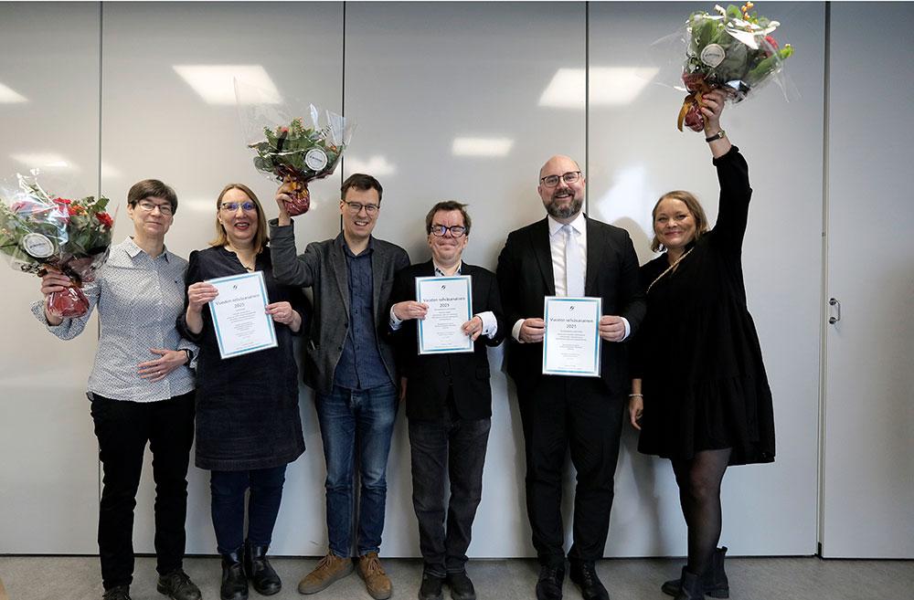 Flera personer på bild med blommor och diplom i handen.