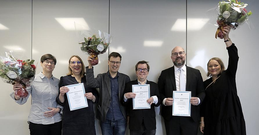 En grupp personer med blommor och diplom.